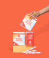 Hand holding organic cotton tampons against an orange background